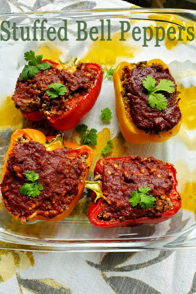 Photo of four freshly baked stuffed bell peppers using multi-colored peppers. 