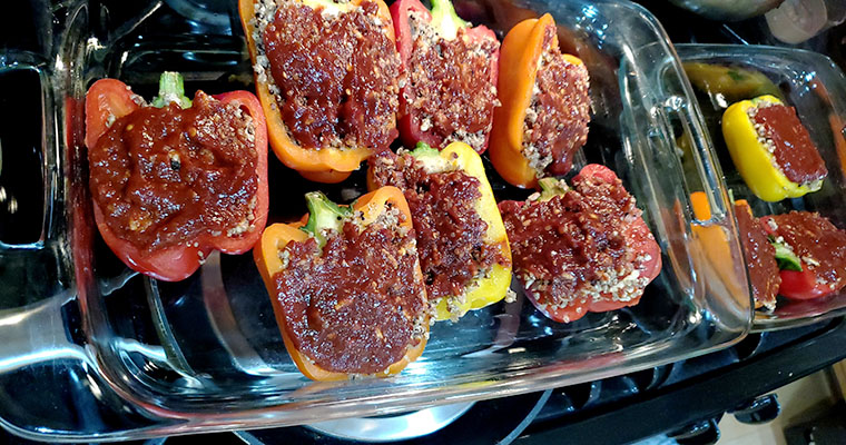 Stuffed bell peppers with spicy garlic tomato sauce before going in the oven.