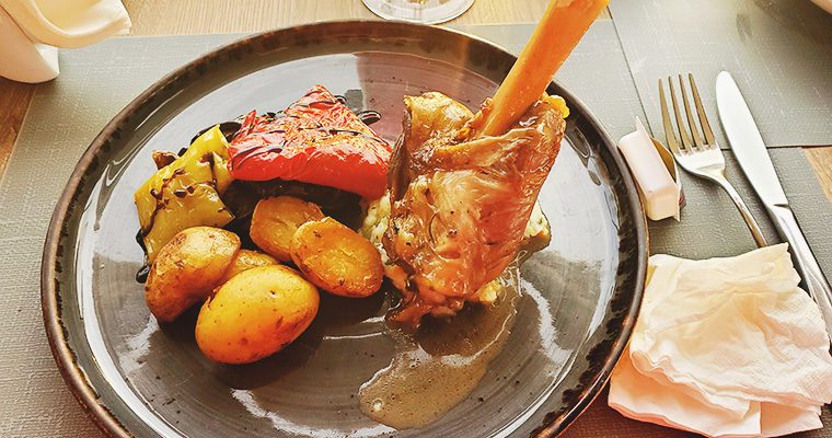 This is an image of the lamb main course at Pelekanos in Santorini, Greece. The lamb was served with potatoes and roasted vegetables.