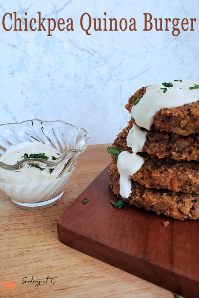This is an image of 4 chickpea quinoa burgers stacked and topped with a lemon garlic tahini dressing.