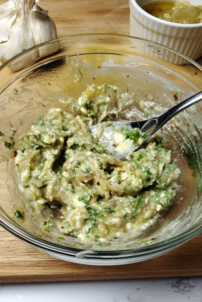 This is an image of smashed garlic confit mixed with fresh parsley, vegan butter, red pepper flakes, and a pinch of salt for the garlic confit toast.