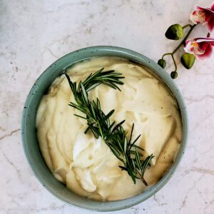 This is an image of the garlic mashed cauliflower garnished with fresh rosemary.