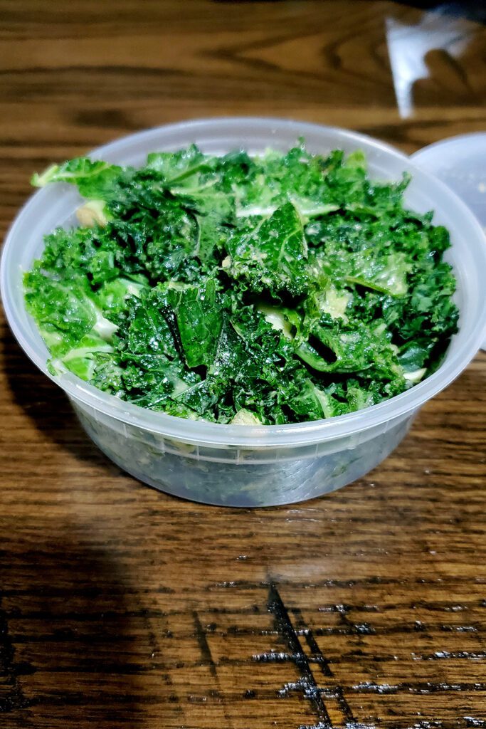 This is an image of the garlic kale salad from NuVegan Cafe, which was the inspiration for the kale salad with tahini dressing.