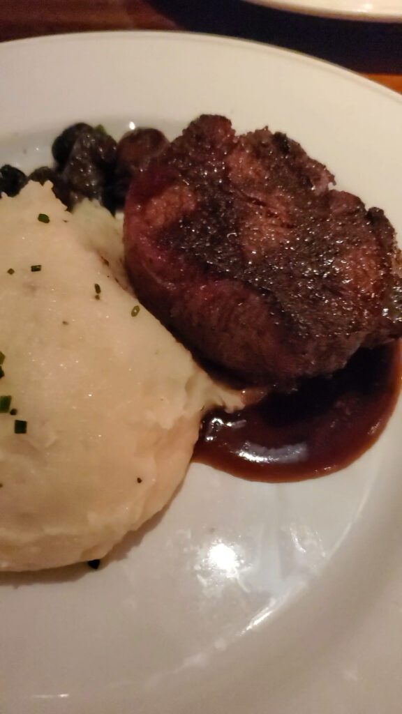 This is an image of the Wood Grilled Filet Mignon from Coastal Flats in Fairfax, VA. The steak was served with roasted cremini mushrooms, mashed potatoes, and a field green salad.