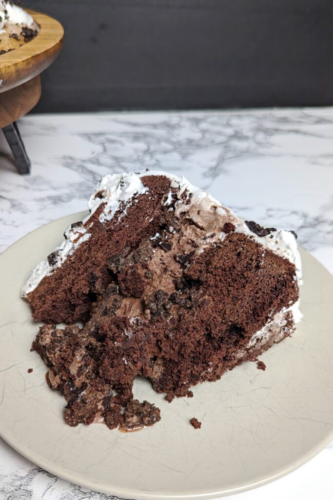 This is an image of the gluten-free 5-layer chocolate ice cream cake. This death by chocolate ice cream cake is made with a gluten-free chocolate cake, gluten-free Oreos, chocolate ice cream, chocolate syrup, Reese's peanut butter ice cream topping, and whipped cream. This image shows one slice of the cake.