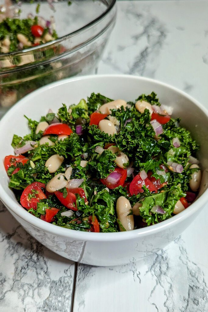 This is an image of the Mediterranean white bean salad with cannellini beans, red onions, tomatoes, parsley, mint, lemon, salt, and pepper.