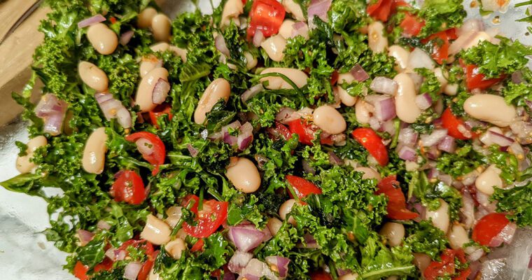 This is an image of the Mediterranean white bean salad with cannellini beans, red onions, tomatoes, parsley, mint, lemon, salt, and pepper.