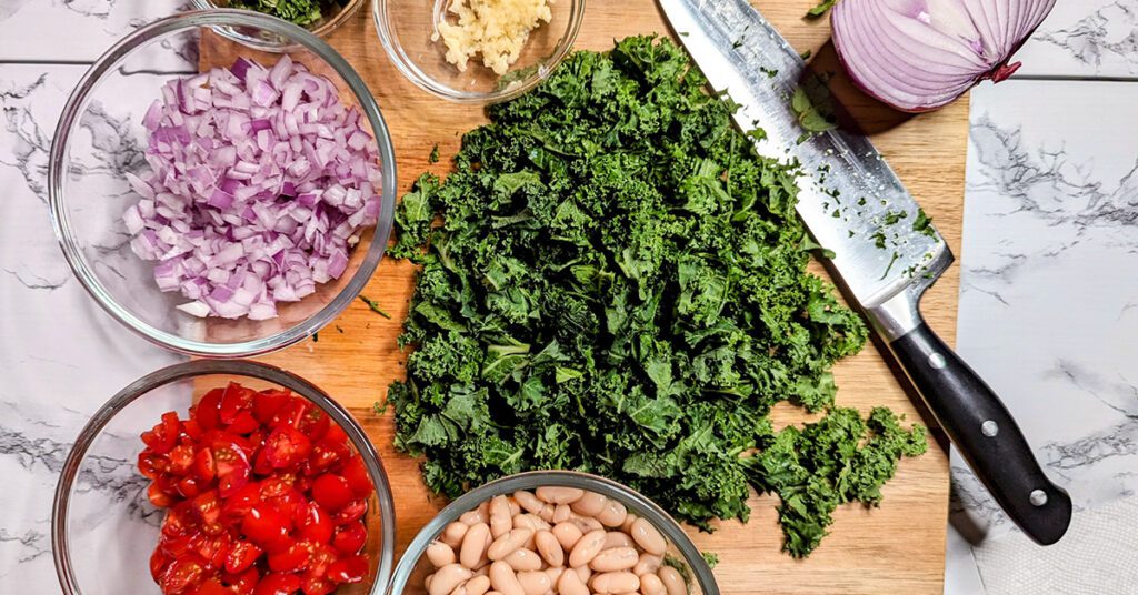 This is an image of the ingredients for the Mediterranean white bean salad with cannellini beans, red onions, tomatoes, parsley, mint, lemon, salt, and pepper.