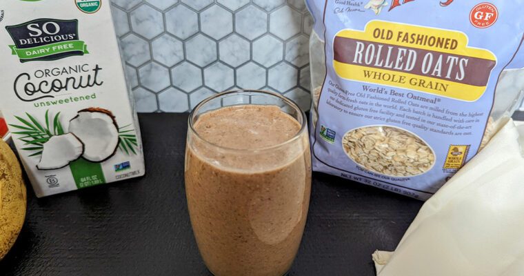 This is an image of the chocolate chia banana smoothie from Sundays at T's. The image is staged with So Delicious Organic Coconut milk, Bob's Red Mill gluten-free rolled oats, and bananas.