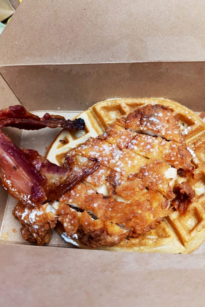 This is an image of Café Avalaun's gluten-free chicken and waffles with a side of bacon.