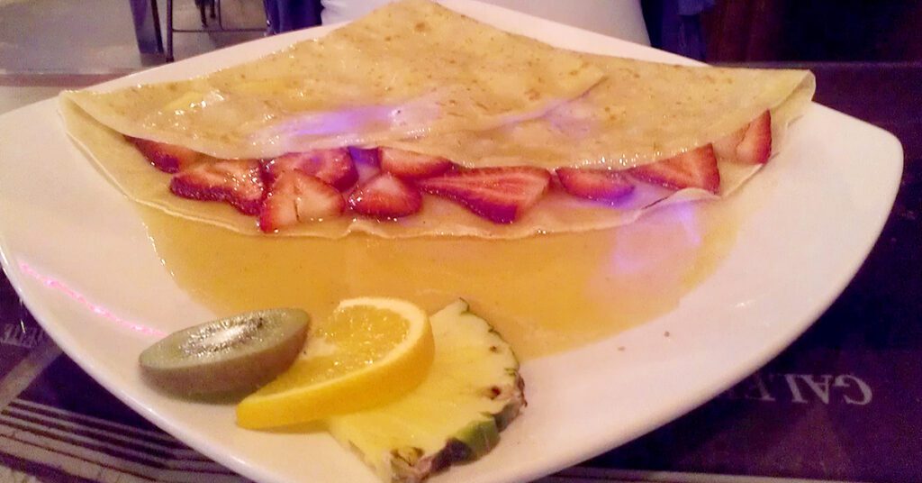 This is an image of a Grand Marnier crepe on fire at a creperie.
