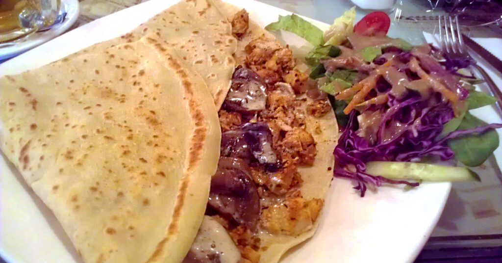 This is an image of savory crepe served with a salad. There are so many delicious creperies in Montreal, Quebec, Canada. Try one today!